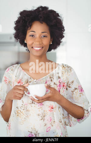 Portrait of smiling woman holding white cup Stock Photo