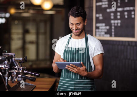 Smiling barista using tablet Stock Photo