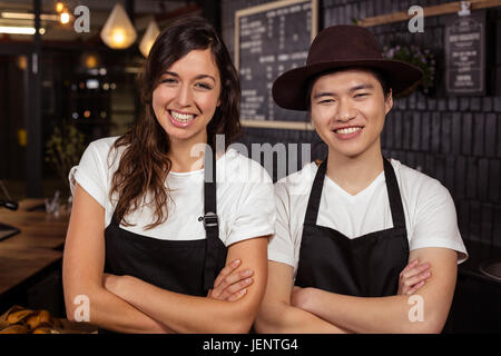 Smiling co-workers posing with crossed arms Stock Photo