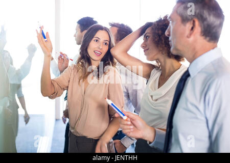 Businesspeople writing on white board Stock Photo