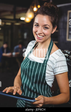Smiling barista using tablet Stock Photo