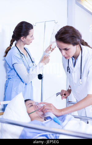 Doctors putting an oxygen mask on patient Stock Photo