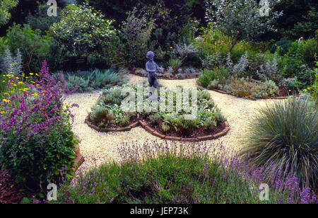 Herb and flower garden with pied piper sculpture Stock Photo