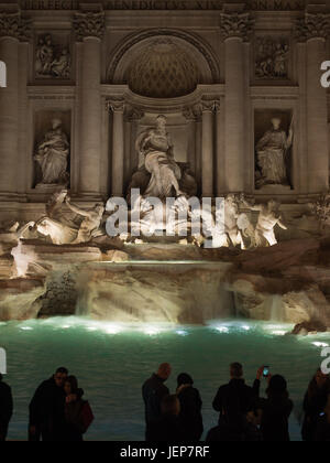 Tourists taking pictures of Fontana di Trevi at night Stock Photo