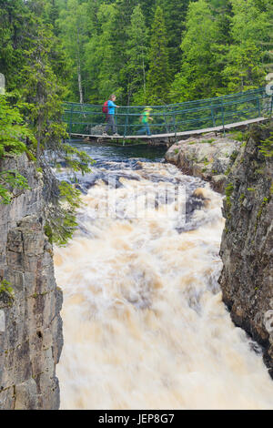 Person crossing footbridge over river Stock Photo