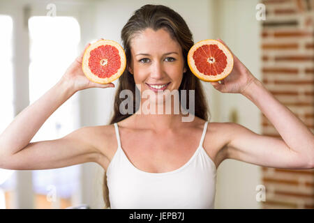 Young woman holding slices of blood orange Stock Photo