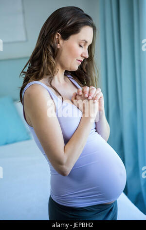 Pregnant woman holding her hands together Stock Photo