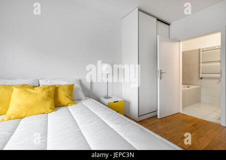 Modern, white bedroom with closet and private bathroom Stock Photo