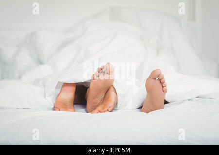 Feet sticking out from the blanket Stock Photo