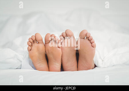 Feet sticking out from the blanket Stock Photo