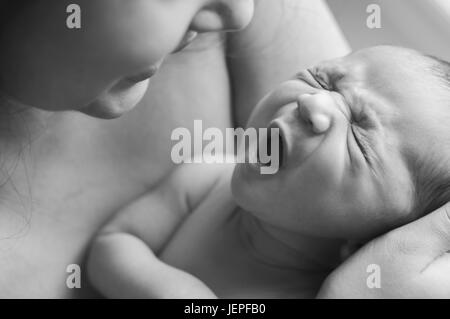 Model Released Photograph of a Baby yawning on his mothers lap Stock Photo