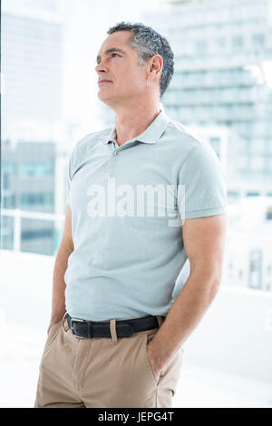 Tensed man standing against window Stock Photo