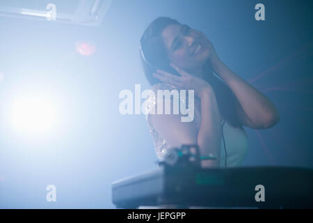 Pretty female DJ playing music Stock Photo