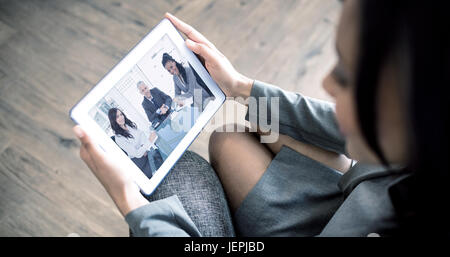 Composite image of businesswoman using tablet Stock Photo