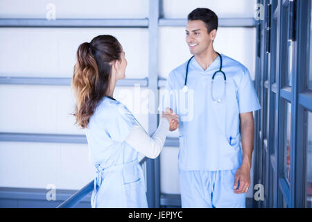 Doctors shaking hands in corridor Stock Photo