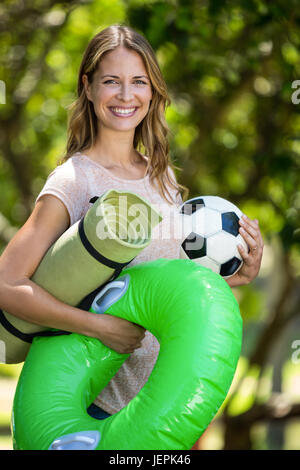 Smiling woman holding different things Stock Photo