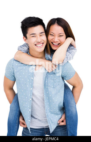 Joyful young man giving a piggyback ride to his girlfriend at store ...