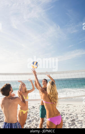 Happy friends playing beach volleyball Stock Photo