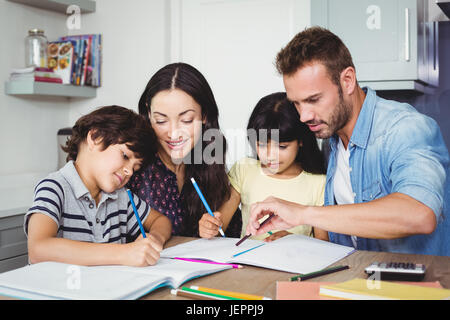 Parents assisting children doing homework Stock Photo