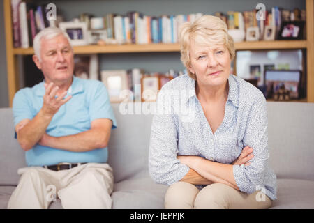 Senior couple arguing while sitting on sofa Stock Photo