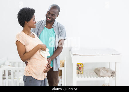 Pregnant couple holding white baby shoes Stock Photo