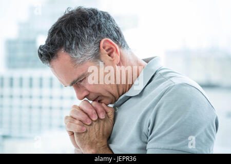 Tensed man standing against window Stock Photo