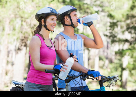 Young couple holding water bottle at forest Stock Photo