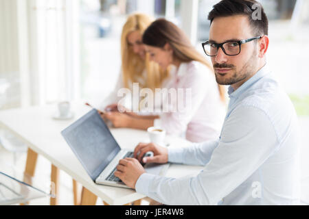 Young handsome employee working on computer during working day in office Stock Photo