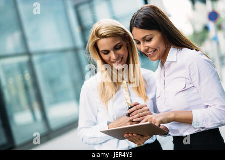 Picture of two young beautiful women as business partners standing outside Stock Photo
