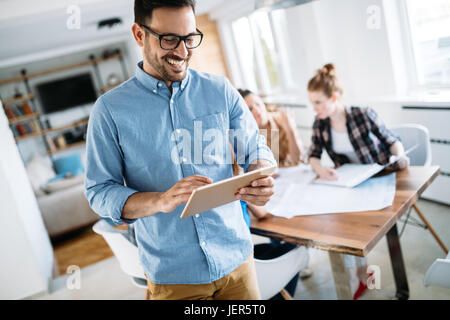 Portrait of handsome young male manager using digital tablet Stock Photo