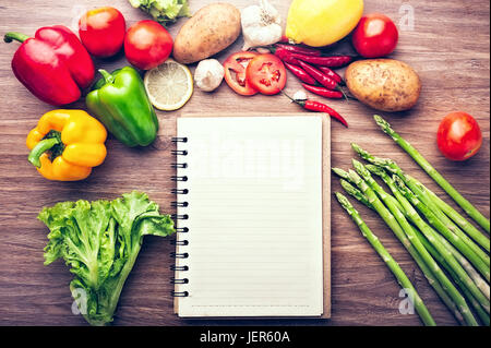 Fresh vegetables on the wooden background and paper for notes Stock Photo