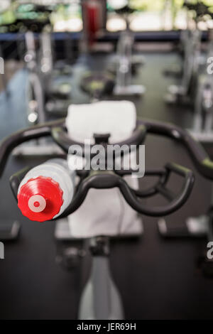 Bottle of water and napkin on exercise bike Stock Photo