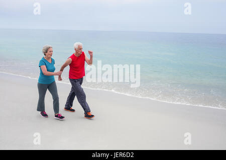Senior couple jogging on the beach Stock Photo