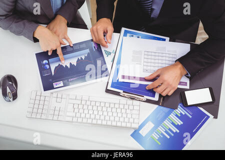 Business people discussing over graph Stock Photo