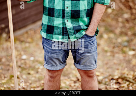 Man in denim shorts, mid section Stock Photo