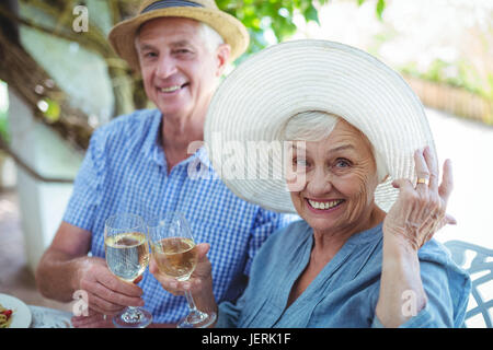 Cheerful retired couple holding white wine Stock Photo