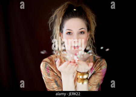 Young woman blowing confetti Stock Photo