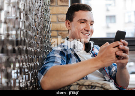 Energetic friendly guy using his gadget Stock Photo