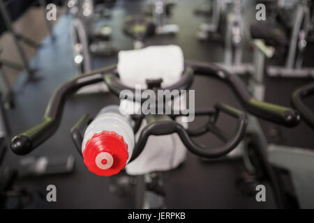 Bottle of water and napkin on exercise bike Stock Photo