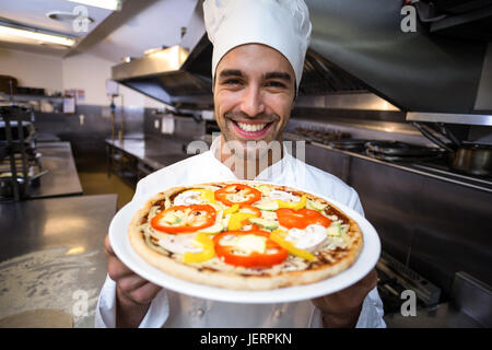 Handsome chef presenting pizza Stock Photo