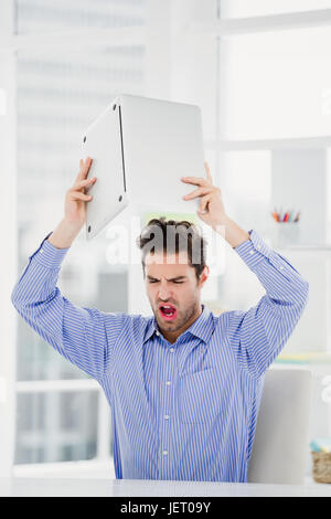 Frustrated businessman throwing laptop Stock Photo