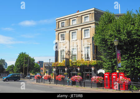 View of the Mitre Hotel and Pub in Greenwich, London in the summer day with unidentified people passing by and the red telephone boxes nearby. Stock Photo