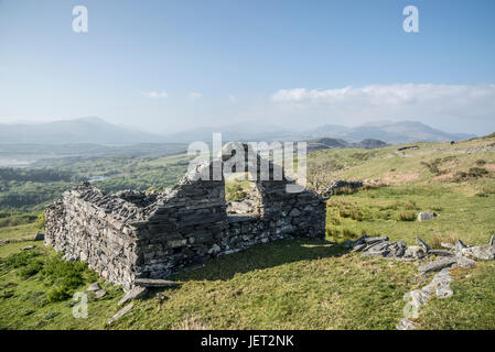 Old stone farm building in the hills near Harlech in Snowdonia, North Wales. Dramatic view of the mountains on a bright afternoon. Stock Photo