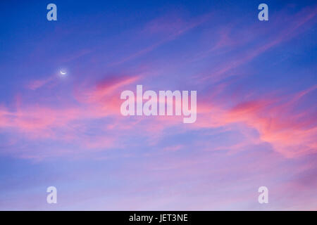 Crescent moon and colorful clouds in the sky. Stock Photo