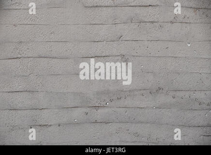 Rough uneven gray beige wall surface of decorative wavy embossed painted lime plaster background texture, close up Stock Photo