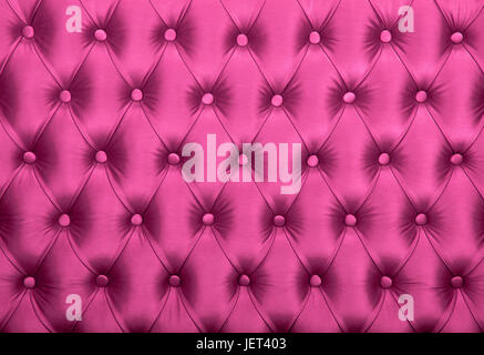 Pink capitone textile background, retro Chesterfield style checkered soft tufted fabric furniture diamond pattern decoration with buttons, close up Stock Photo