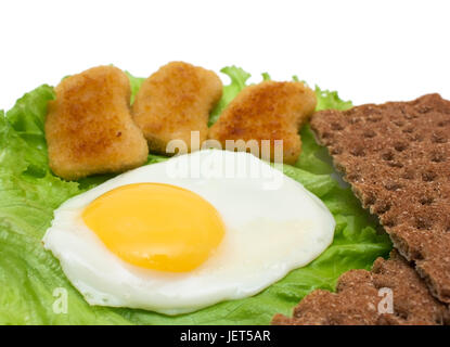 Breakfast copy space: fried egg, lettuce, crisp bread and nuggets isolated on white Stock Photo