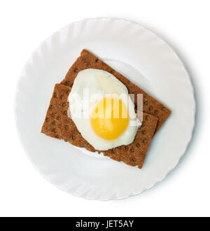 Breakfast: fried egg and crisp bread on plate isolated on white Stock Photo