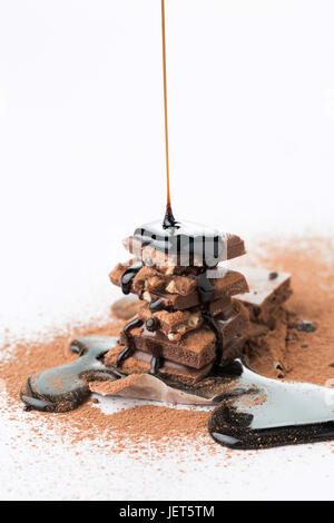 Chocolate with cocoa powder, sprinkled with syrup on empty white background Stock Photo
