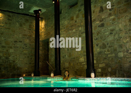 Europe, Italy, Helvetia Thermal SPA Hotel Porretta Terme, woman inside the spa pool with lanterns Stock Photo
